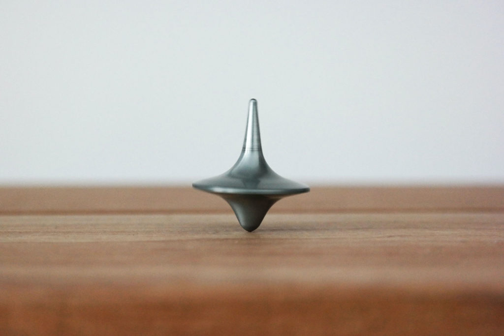 Gray top spinning on a wood table
